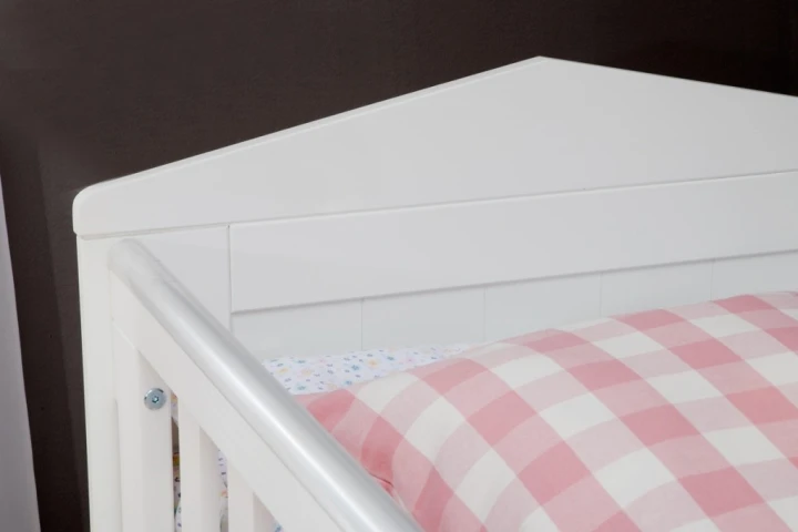 Zbliżenie na plastikowe nakładki ochronne zabezpieczające krawędzie przed gryzieniem w łóżeczku 120x60 Marsylia