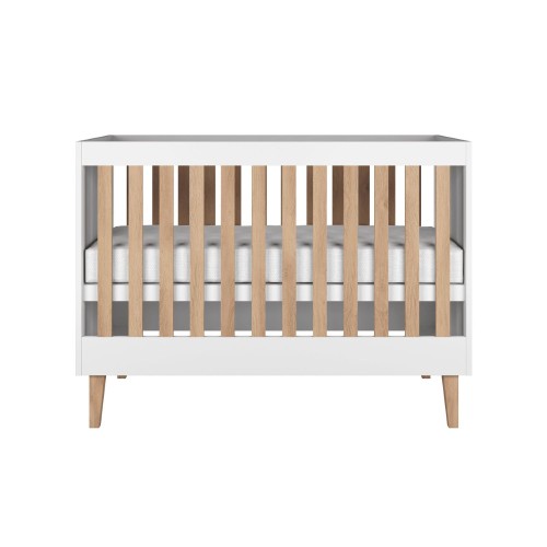 białe łóżeczko niemowlęce z drewnianymi nogami